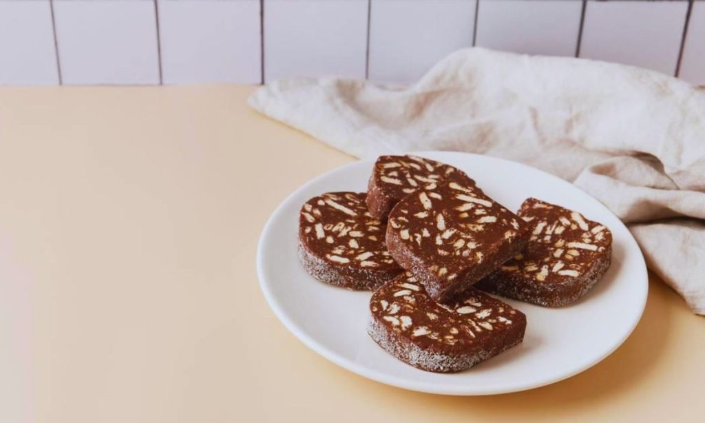 Traditional portuguese dessert Salame de Chocolate on beige background in minimal style. Restaurant bakery menu